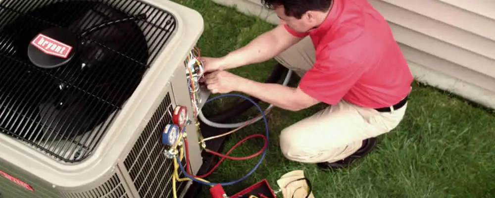 HVAC technician servicing an outdoor air conditioner unit in Grand Rapids, MI