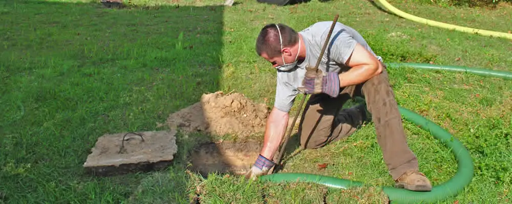 Septic pumping technician servicing a residential septic tank in Grand Rapids, MI