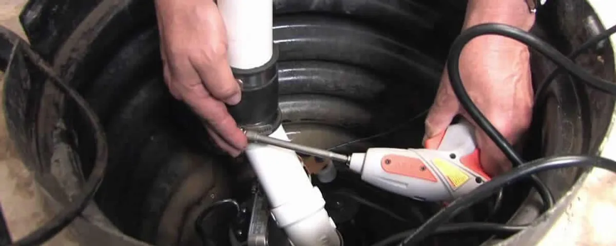 Sump pump installation technician connecting PVC discharge piping in Grand Rapids, MI