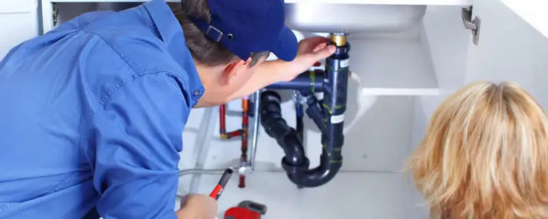 Plumber repairing under-sink drain pipes and fittings in Grand Rapids, MI